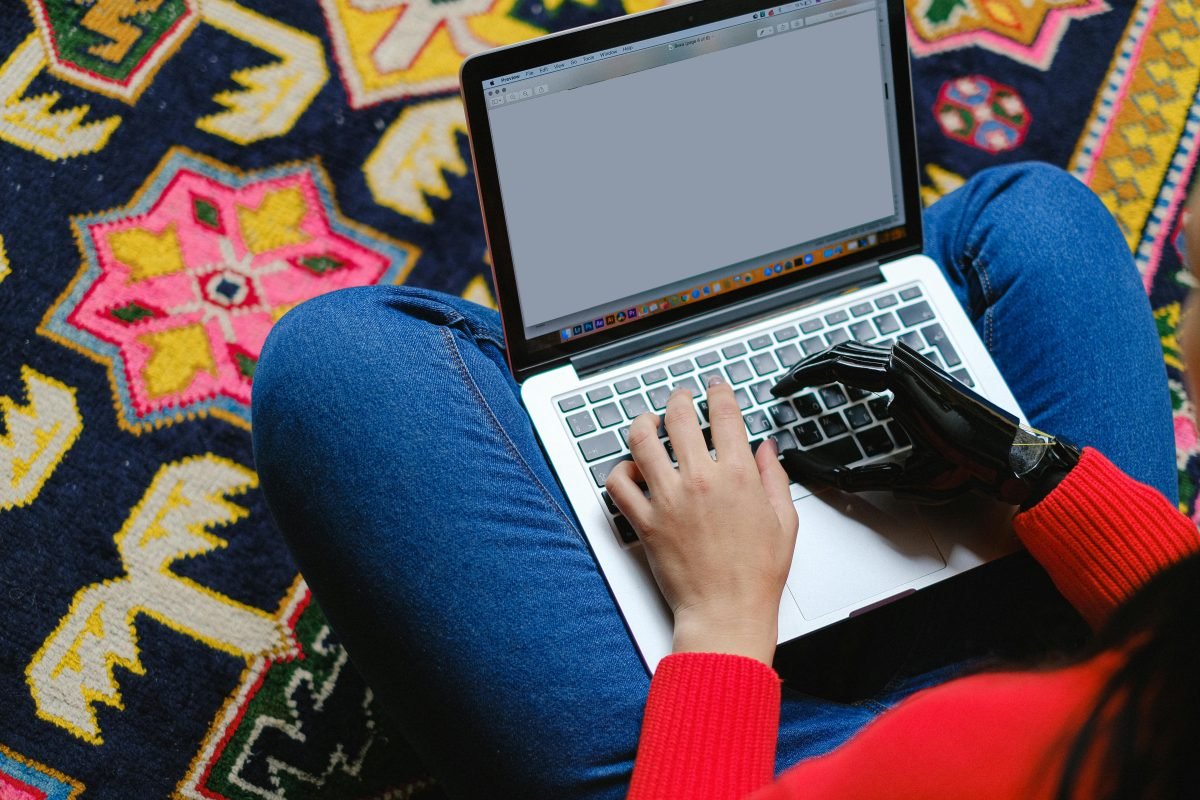 pexels-shvetsa-5614241 Person using a laptop, with a prosthetic hand, symbolizing accessible website design.